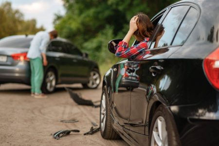 Male and female drivers after car accident on road. Automobile crash. Broken automobile or damaged vehicle, auto collision on highway